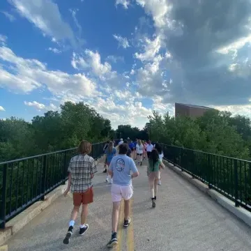 Students waling across footbridge to downtown farmers market